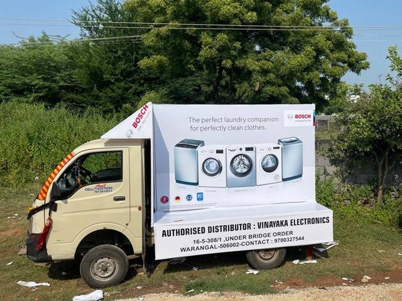 Tata Ace with brand advertisement parked near a residential society, ensuring exposure to local consumers