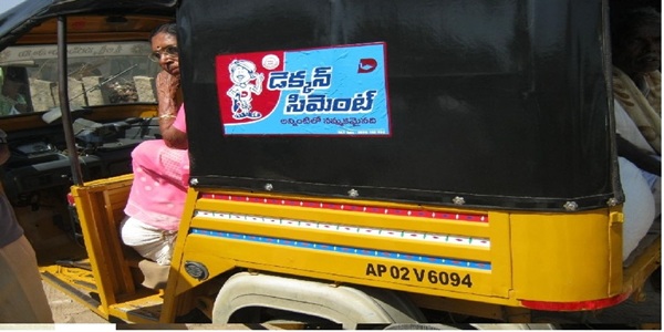 An auto-rickshaw with an Auto Tattoo branding in rainy weather, proving its durability.