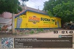 A wall painting advertisement for a retail store displayed in a busy marketplace.